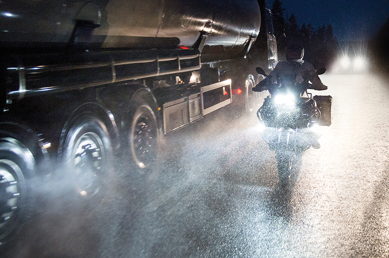 Guy riding motorcycle at night in foul weather